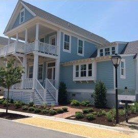 Freshly mulched landscape beds in front of a blue house